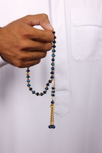 Close-up of hand holding religious beads