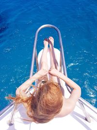High angle view of young woman in swimming pool / woman in blue lagoon / blue lagoon