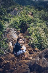 High angle portrait of female hiker sitting on rocks