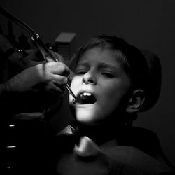 Cropped hands of dentist examining boy