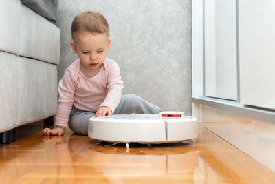 Portrait of cute boy sitting on floor at home