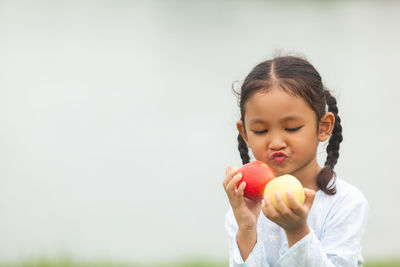 Girl holding apple against white background