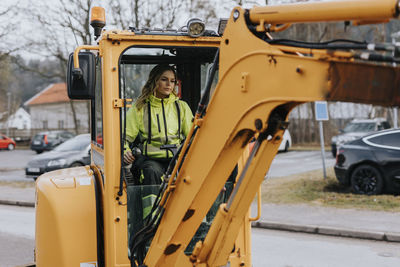 Female road worker operating excavator