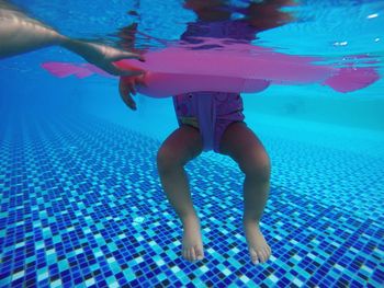 Low section of child in swimming in pool