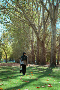 Rear view of woman walking on field