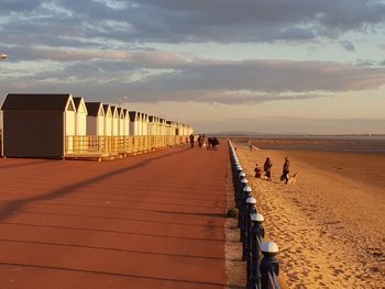 People on beach against sky during sunset