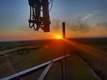 Close-up of vehicle on landscape against sky during sunset