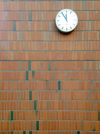 Clock mounted on brick wall