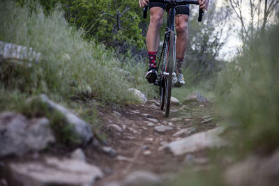 Low section of man cycling on field