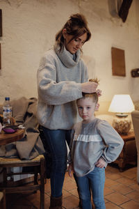 Creating trust and love mother styles 4-year-old daughter's hair in cozy rural home family moments.