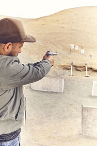 Man with hand gun aiming at shooting range and releasing stress. selective focus