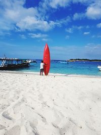 Boy on beach against sky