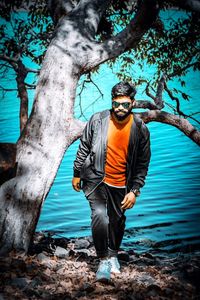 Young man standing on tree trunk