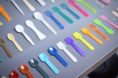 High angle view of multi colored plastic spoons on table
