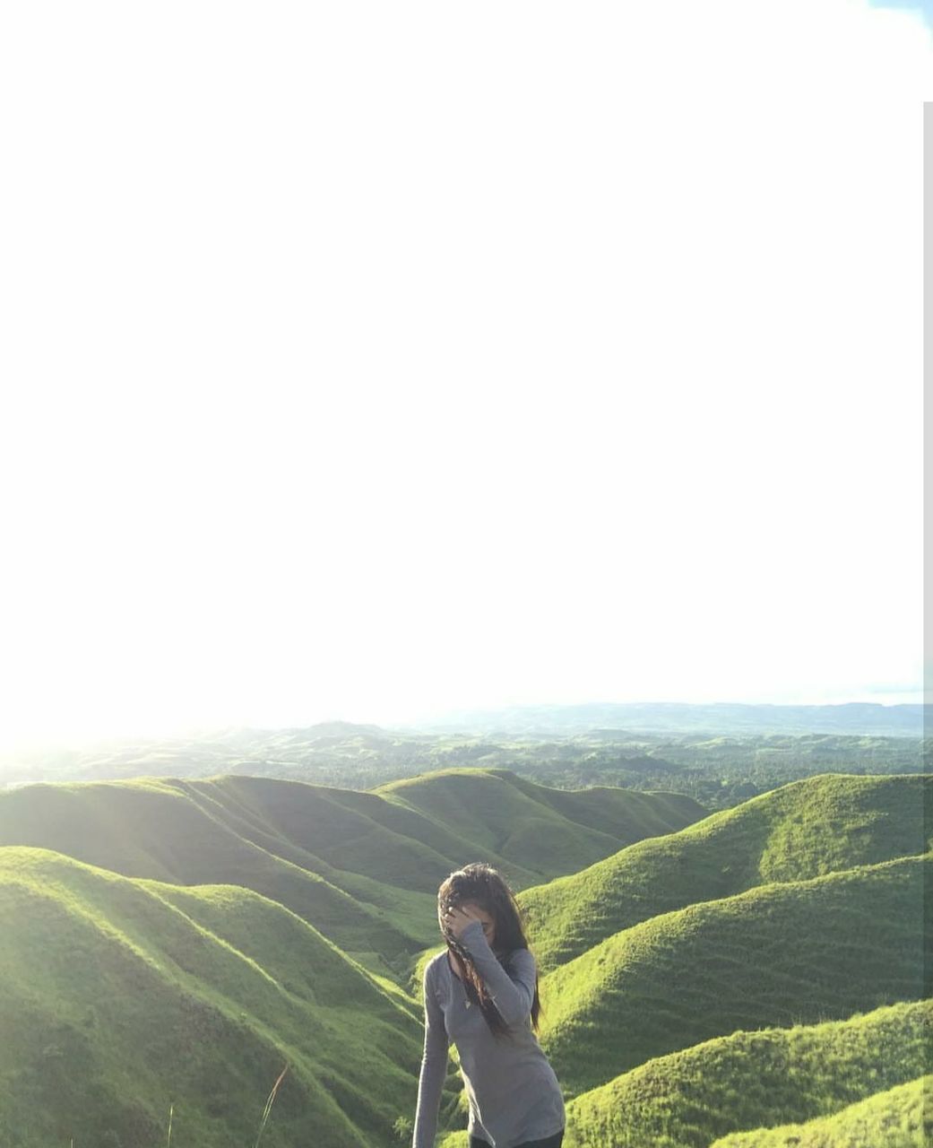 one person, beauty in nature, scenics - nature, environment, landscape, leisure activity, real people, copy space, sky, lifestyles, tranquil scene, clear sky, day, nature, tranquility, mountain, land, green color, non-urban scene, standing, outdoors, looking at view