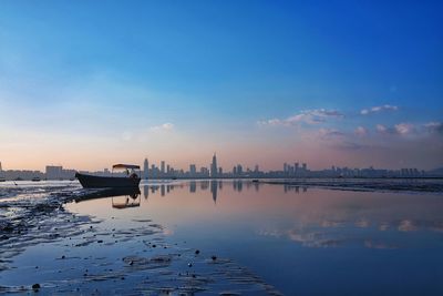 Scenic view of city coastline at sunset