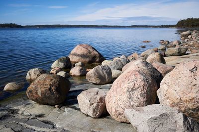 Stack of rocks by sea against sky