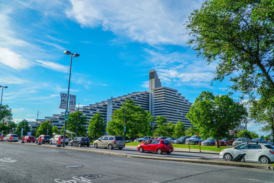 Cars on road in city against blue sky