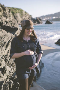 Full length of woman standing by sea during winter