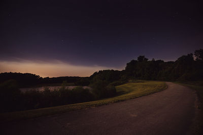 Road amidst landscape against sky at night