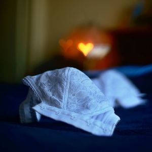 Close-up of lit candles on bed at home