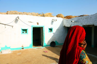 Rear view of woman in traditional clothing outside house