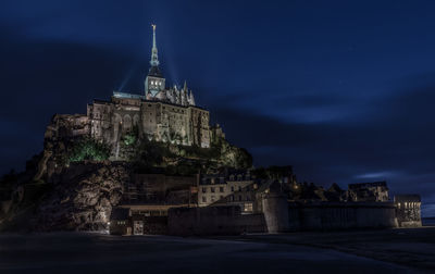 Historic building against blue sky at night