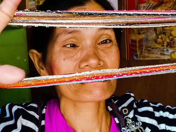 Close-up of woman looking at multi colored thread