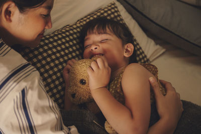 Mother and daughter sleeping on bed at home