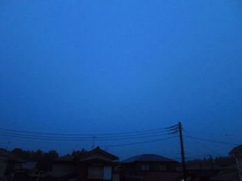 Electricity pylons against clear blue sky