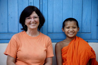 Portrait of smiling woman sitting with monk