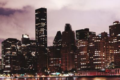 Illuminated buildings in city against sky