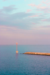 Lighthouse by sea against sky