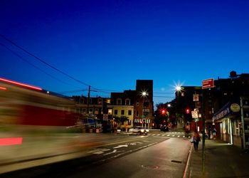 Blurred motion of city street against blue sky
