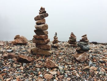 Stack of stones on beach against sky