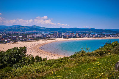 Scenic view of beach and city against sky