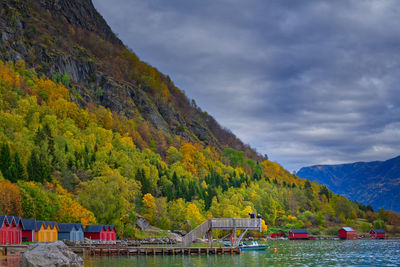 Father and daughter wave from the end of a diving platform over turquoise water in fall