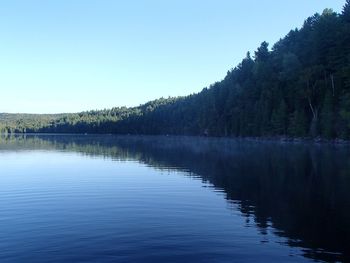 Scenic view of lake against clear blue sky