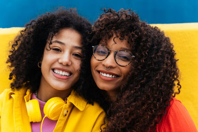 Portrait of smiling friends against wall