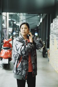 Portrait of young woman standing in city