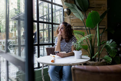 Woman looking through window at cafe