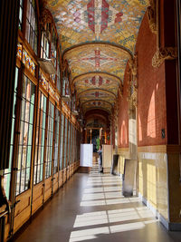 Rear view of woman walking in corridor of building