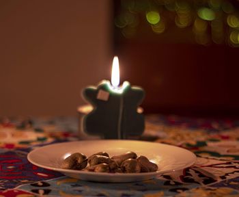 Close-up of burning candles on table