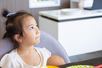 Portrait of cute girl looking at camera at home