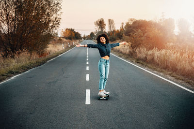 Portrait of man skateboarding on road