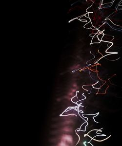 Low angle view of illuminated light painting against wall at night