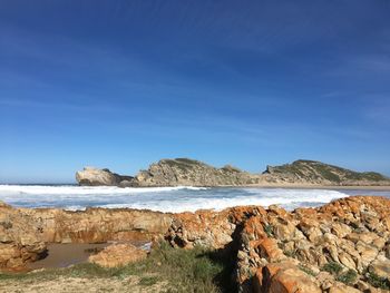 Scenic view of beach against blue sky