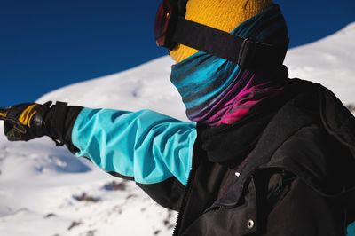 Side view of a tourist pointing with his hand in the right direction. young man looking for