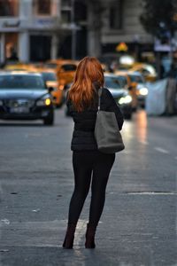 Rear view of woman walking on street in city