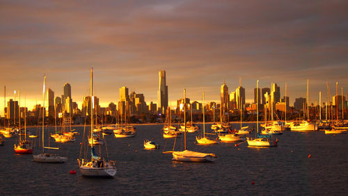 Boats moored in sea at sunset